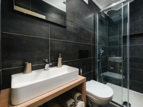 a bathroom with a sink and a toilet and a shower at Apartment Urban Black in Poreč