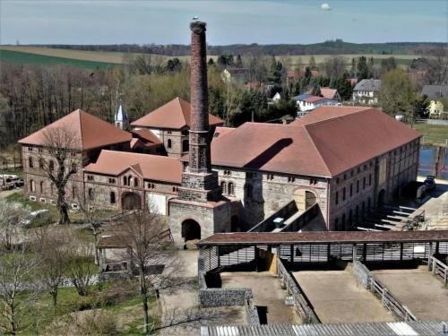 an old brick building with a chimney and a factory at Tiny House near Dresden in Lauterbach
