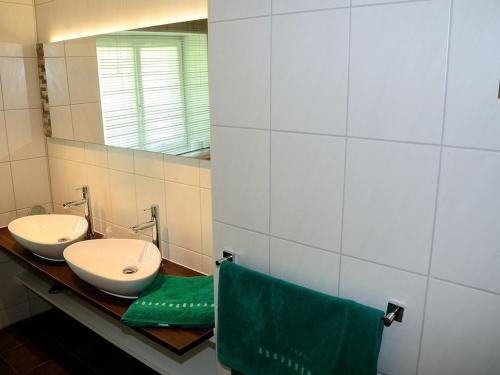 a bathroom with two sinks and a mirror at Cabin in Ofterschwang with swimming pool in Sigiswang