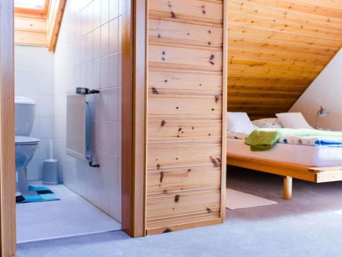a bedroom with a bed and a wooden wall at Holiday home with 2 bedrooms in Burggaillenreuth