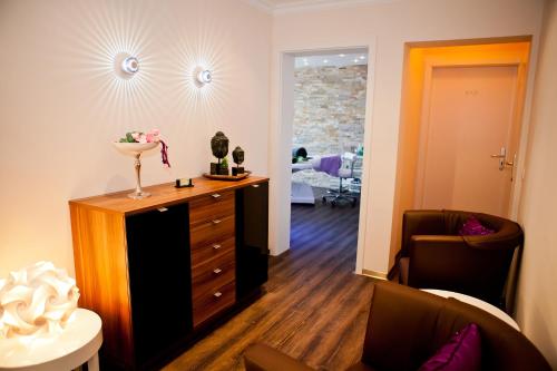 a living room with a dresser and a chair at Thermalhotel Gass in Bad Füssing