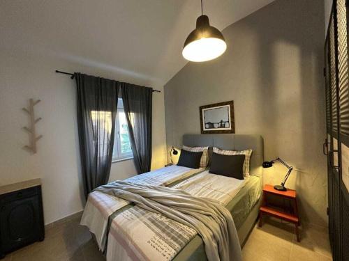una camera da letto con un letto con una lampada e una finestra di Apartment Urban Green a Poreč (Parenzo)