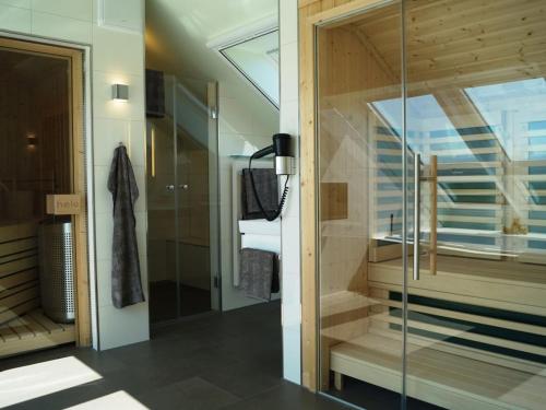 ホーヴァハトにあるApartment in Hohwacht with swimming poolのガラスのシャワーと洗面台を備えたバスルーム