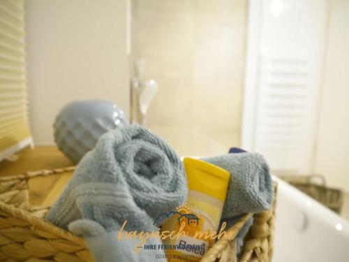 a basket filled with towels and other bathroom items at Bavarian holiday apartment more in Gstadt am Chiemsee