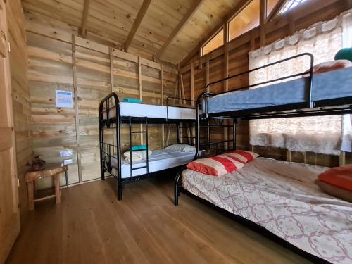 Buenos AiresにあるCabañas Bonnysuの木製の壁の客室で、二段ベッド2組が備わります。