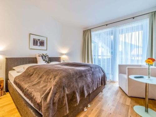 a bedroom with a large bed and a large window at One-bedroom apartment in Kalzhofen