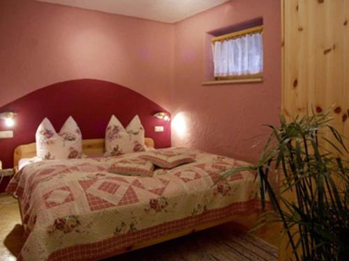 a bedroom with a bed with a red headboard at Holzer Feng Shui in Rettenberg