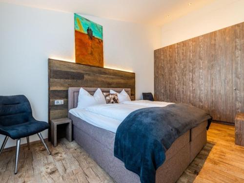 ein Schlafzimmer mit einem großen Bett und einem Stuhl in der Unterkunft Holiday apartment with 2 bedrooms in Kalzhofen