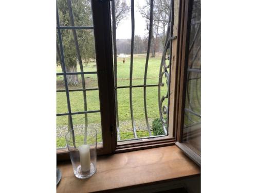 a glass of milk sitting on a window sill at Castle Apartment "Cook" in Maroldsweisach