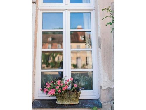 a window with a basket of flowers on a window sill at Castle Apartment "Cook" in Maroldsweisach