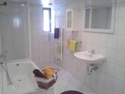 a white bathroom with a tub and a sink at One-bedroom apartment in Cobbenrode