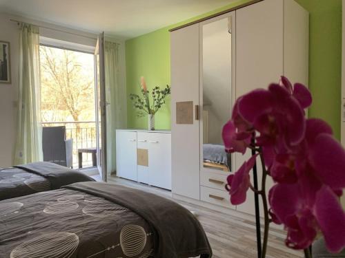 a bedroom with a bed and a purple orchid at Long 4 stars with balcony in Schauenstein