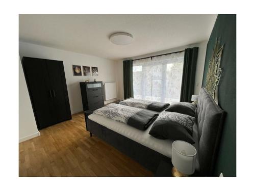 a bedroom with a bed with a couch and a window at Holiday home with 2 bedrooms in Schopfloch