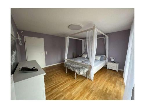 a bedroom with a canopy bed and a wooden floor at Holiday home with 2 bedrooms in Schopfloch