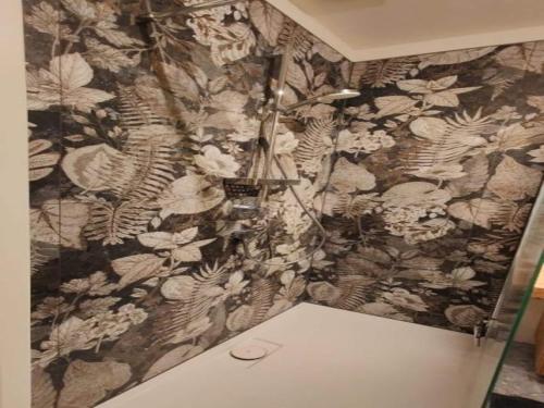 a bathroom with a floral patterned wall at Lichtdurchflutetes Apartment mit Sauna & Kamin in Lauterbach