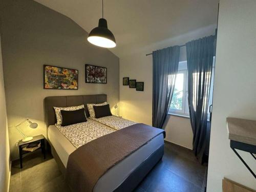 una camera da letto con un letto e una finestra di Apartment Urban Grey a Poreč (Parenzo)