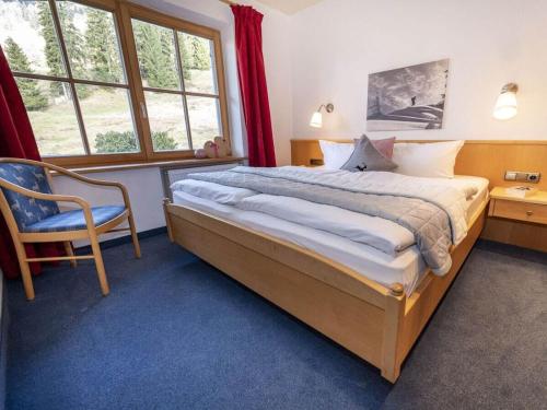 a bedroom with a large bed and a chair at Sun meadow sauna, dogs allowed in Balderschwang