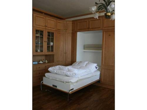 JauchenにあるHoliday apartment in Oberstdorf with Wi-Fiのベッドルーム1室(ベッド1台、木製キャビネット付)