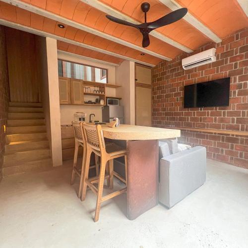 a kitchen with a table with chairs and a ceiling fan at Casa Xaviera in Puerto Escondido