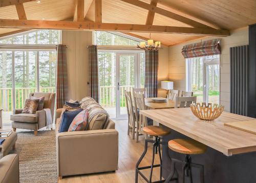 a living room with a table and chairs at Thirlestane Woodland Lodges in Lauder