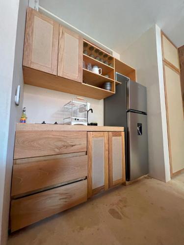 a kitchen with wooden cabinets and a stainless steel refrigerator at Casa Xaviera in Puerto Escondido