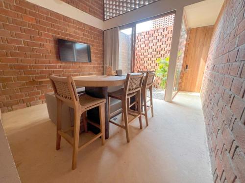 a table and chairs in a room with a brick wall at Casa Xaviera in Puerto Escondido