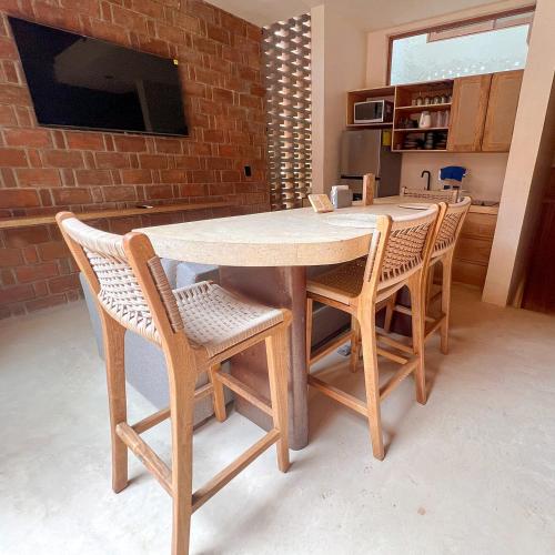 a wooden table and chairs in a kitchen at Casa Xaviera in Puerto Escondido