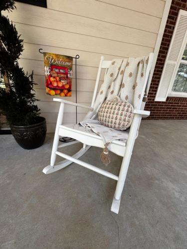 a white rocking chair sitting on a porch at Opus House Historic Natchitoches in Natchitoches
