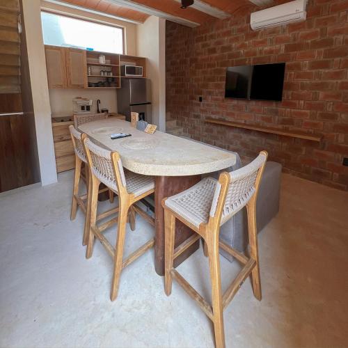 a table and chairs in a kitchen with a brick wall at Casa Xaviera in Puerto Escondido