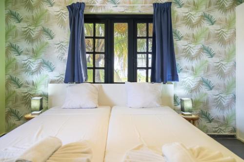 two beds in a room with a window at Resort Bonaire in Kralendijk