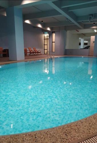 a large swimming pool with blue water in a building at Home away from home in Bandar Seri Begawan