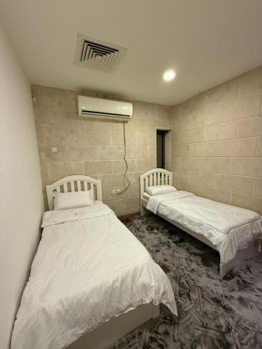 アル・コバールにあるالخبر الشمالية 2の壁のある部屋にベッドが2つある