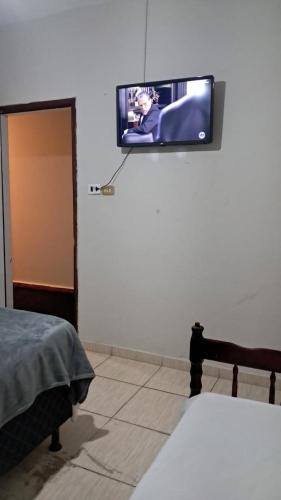 a flat screen tv hanging on a wall in a bedroom at Hotel Eldorado in Eldorado