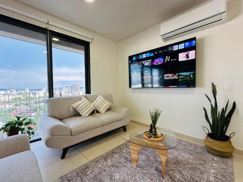a living room with a couch and a large window at Modern 2BR Condo in Providencia, City Views, Pool & Gym in Guadalajara