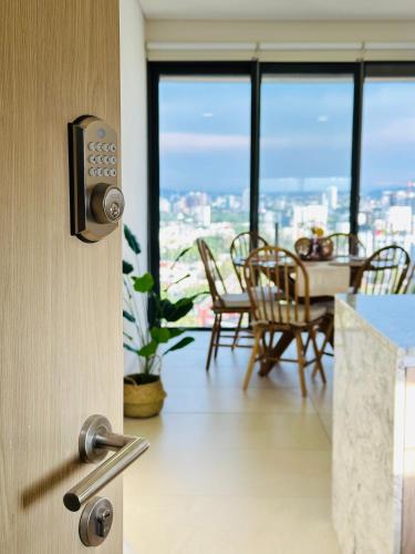 a room with a door with a table and chairs at Modern 2BR Condo in Providencia, City Views, Pool & Gym in Guadalajara