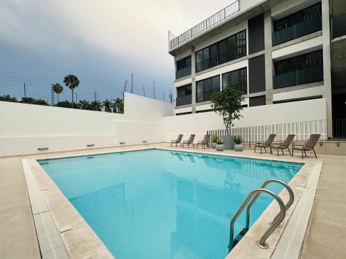 a swimming pool in front of a building at Modern 2BR Condo in Providencia, City Views, Pool & Gym in Guadalajara