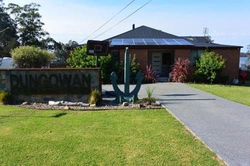 a house with a basketball hoop in the driveway at Dungowan Holiday Accommodation in Erowal Bay