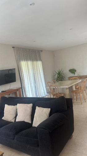 a living room with a black couch and a table at Rincón de Chacras de Coria in Ciudad Lujan de Cuyo