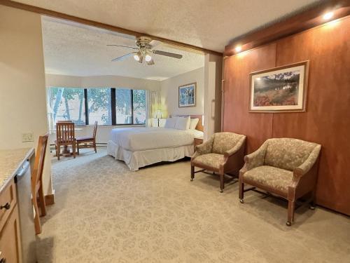 Mount Crested ButteにあるGrand Lodge Studio Pool Hot Tub Pets Skiingの広いベッドルーム(ベッド1台、椅子2脚付)