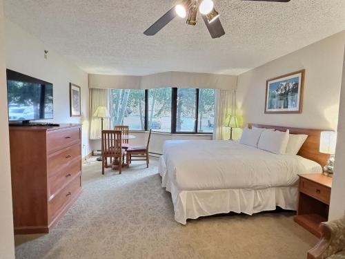 Mount Crested ButteにあるGrand Lodge Studio Pool Hot Tub Pets Skiingのベッドルーム1室(大型ベッド1台、テーブル、椅子付)