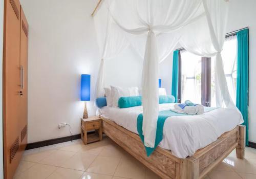 een slaapkamer met een groot bed met een baldakijn bij Villa Marjens 2 Seminyak area Bali in Kerobokan