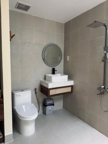a bathroom with a toilet and a sink and a mirror at Malis Homestay in Trà Vinh