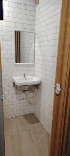 a white bathroom with a sink and a mirror at Saya & Awak Tiny House in Kota Bharu