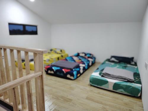 three beds sitting in a room next to a staircase at Saya & Awak Tiny House in Kota Bharu