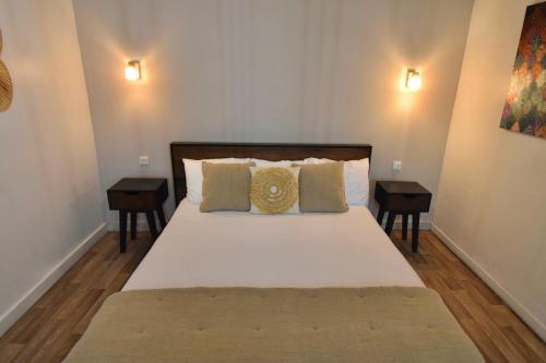 a bedroom with a large bed with two night stands at Koho SXM - ex Hevea Hotel in Grand Case