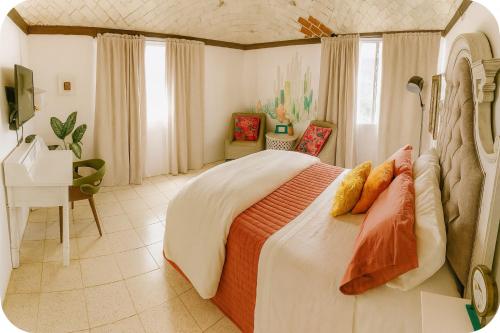 a bedroom with a large bed and a desk at Casa de Guijas Tradition Art and Hospitality in Guanajuato