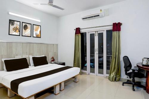 a bedroom with a bed and a desk and a window at Super Townhouse Medavakkam Near Jayachandran in Chennai