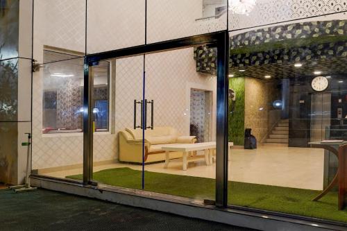 a view of a living room through a glass door at Super Townhouse Medavakkam Near Jayachandran in Chennai