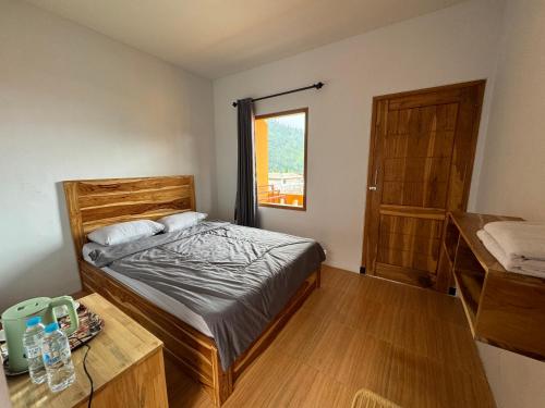 a bedroom with a bed and a table and a window at Homestay Lereng Bromo in Bromo