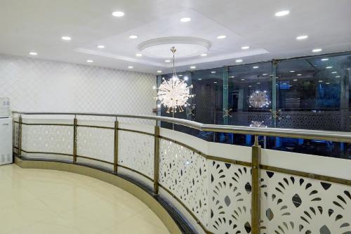 a staircase in a room with a chandelier at Super Townhouse Medavakkam Near Jayachandran in Chennai